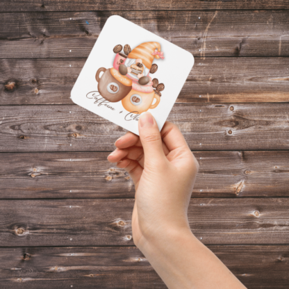 A Product image of 1 of 4 coasters with a watercolor gnome, illustrated with coffee beans, and a coffee mug over the words Caffeine and Chaos