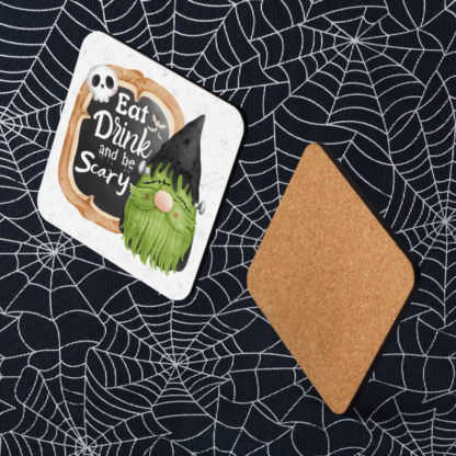 A product image of a of beverage coaster with watercolor illustrated a gnome vampire with the words Eat, Drink, and be Scary