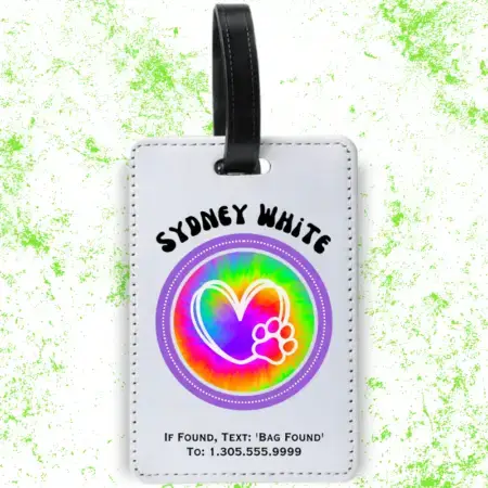 A product image of a luggage tag with the traveler's full name, if found text keyword and mobile phone number, tie dye printed with a heart and paw in the center of a purple circle