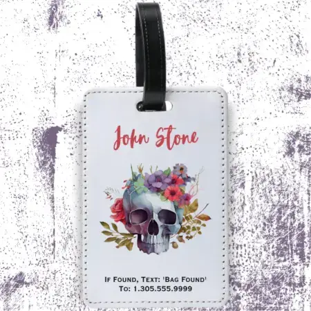 A product image of a luggage tag with the traveler's full name, if found text keyword and mobile phone number, printed with a skull surrounded by colorful flowers