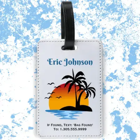 A product image of a luggage tag with the traveler's full name, if found text keyword and mobile phone number, printed with the a sun setting behind island palm trees, ocean water, and birds flying