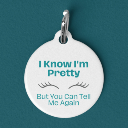 A product image of a funny pet id tag with cute eyelashes that states I know I'm Pretty But You Can Tell Me Again printed around it