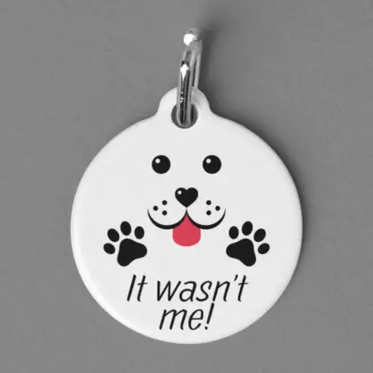 A product image of a aluminum pet tag that looks like a cute puppy and paws with the words It wasn't me!