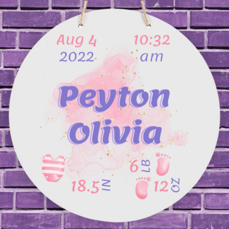 A product image of a personalized baby girl photo prop announcement with the baby's first name, baby's middle name, baby's length in inches, baby's weight in pounds and ounce, baby's date of birth, time of birth, printed with an alcohol ink background, illustrated watercolor baby footprints, and a a pink striped outfit