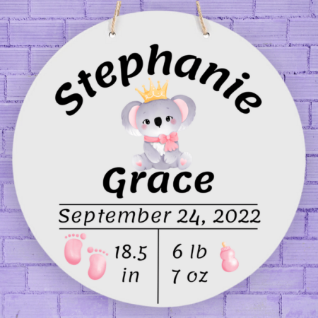 A product image of a personalized baby girl photo prop announcement with the baby's first name, baby's middle name, baby's length in inches, baby's weight in pounds and ounce, baby's date of birth, printed with an alcohol ink background, illustrated watercolor baby footprints, and a baby's bottle with a watercolor koala baby