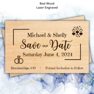 A product image of wood wedding announcement cards, engraved with the words Save the date, the date of the wedding, the bride's name, the groom's name or the bride's name and the bride's name, or the groom's name and the groom's name, with a note of location and the need to watch for a formal invitation. Two rings and a group of hearts are also engraved in this design.