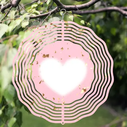 A product image of a 3D wind spinner with powder pink background with gold confetti and the beating heart.