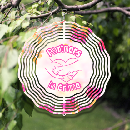 A product image of a 3D wind spinner with flower background. One side has a person's hand and a dog's paw with the words Partners in Crime. The second side has 2 hearts